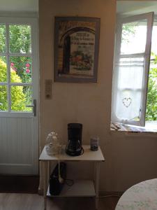 a coffee maker on a table next to a window at La Closerie in Saint-Philbert-du-Peuple