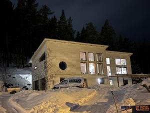 a house with a car parked in front of it in the snow at Lake View Villa in Falun +4 photos