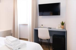 a bedroom with a desk and a white chair at Guest house - L'amante e il marinaio in Fiumicino