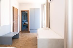a white room with a bench and a bathroom at Guest house - L'amante e il marinaio in Fiumicino +66 photos