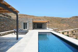 a swimming pool in front of a stone house at Kymo Kea in Otziás