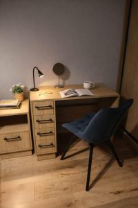 a desk with a chair and a lamp on it at APART FLOW Walendów Park in Nadarzyn