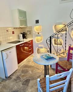 a small kitchen with a table and chairs in a room at Peaceful Cycladic Studio with Large Terrace & View in Tripiti