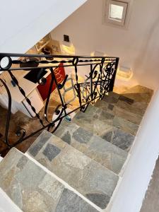 a staircase with a wrought iron railing in a house at Peaceful Cycladic Studio with Large Terrace & View in Tripiti