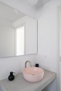 a bathroom with a pink bowl sink on a counter at Kymo Kea in Otziás +31 photos