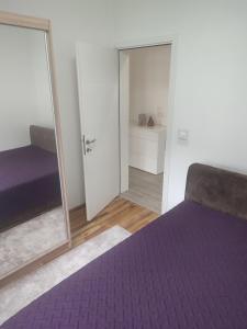 a bedroom with a purple bed and a mirror at Bar ,2 sobni stan ,Namaste ! in Bar