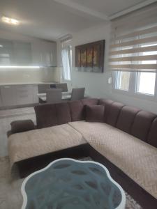 a living room with a brown couch and a table at Bar ,2 sobni stan ,Namaste ! in Bar