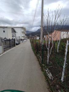 an empty road next to a fence with trees on the side at Bar ,2 sobni stan ,Namaste ! in Bar