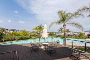 a patio with a table and chairs next to a pool at 2 Bedroom 2 Bathroom Executive Suite in Midrand
