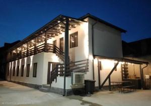 a white building with lights on the side of it at URBANIST Guest House in Călimăneşti