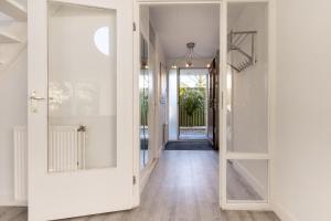 an open door leading to a hallway with white walls at Villa Beach & Spa in Julianadorp +51 photos