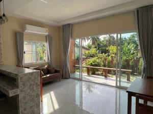 a living room with a large sliding glass door at The Triangle Villas in Srithanu