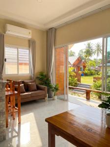 a living room with a couch and a table at The Triangle Villas in Srithanu