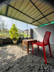 a patio with two chairs and a table and a bench at Avenue Dorms in Kalpetta