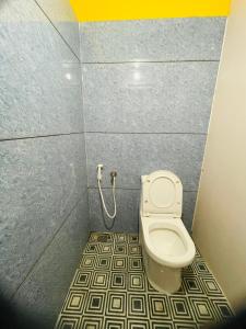 a bathroom with a toilet in a stall at Avenue Dorms in Kalpetta