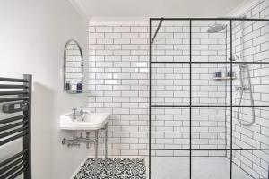 a bathroom with a sink and a glass shower at Knoll House in Studland