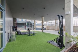 an indoor gym with green grass and tread machines at Home and CoLiving Pamplona in Pamplona