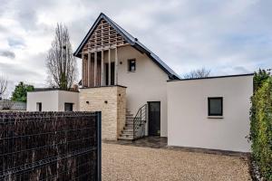 a white house with a black roof and a fence at Coquelicot in Caen