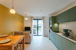 a kitchen and living room with a table and a couch at Coquelicot in Caen +17 photos
