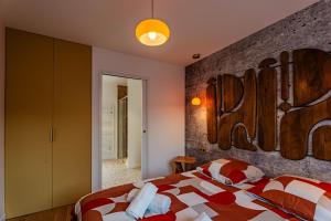 a bedroom with a bed and a brick wall at Coquelicot in Caen
