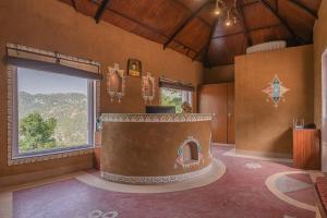 a room with a large fireplace in a room with a window at A Kasauli Ggaon by Echor in Kasauli