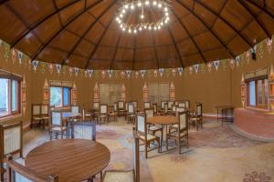 a dining room with tables and chairs and a chandelier at A Kasauli Ggaon by Echor in Kasauli