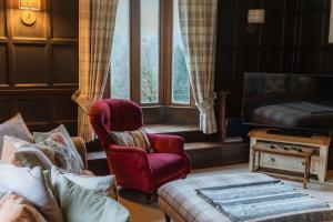 a living room with a chair and a couch and a window at Grey Walls in Penrith