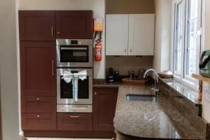 a kitchen with a sink and a stove top oven at Grey Walls in Penrith