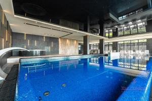 a large swimming pool with blue water in a building at Your Holidays Infinity A233 in Międzyzdroje +20 photos