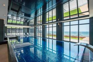 a large swimming pool with a view of the ocean at Your Holidays Infinity A233 in Międzyzdroje