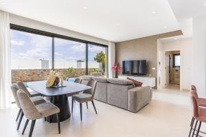 a living room with a couch and a table and chairs at Villa Palmera in San Javier