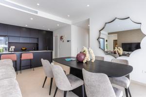 a dining room with a black table and chairs at Villa Palmera in San Javier +144 photos