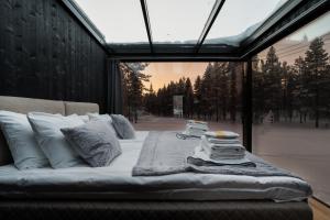 a bed in a room with a large window at Aurora Igloo Village Ylläs - Hot Tub in Ylläsjärvi