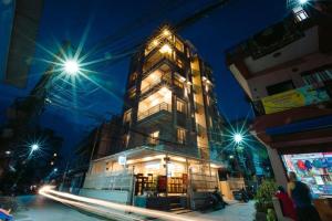 a tall building is lit up at night at A Square Residency Inn in Pokhara