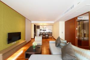 a living room with a couch and a tv at Amanta Hotel & Residence Ratchada in Bangkok +138 photos