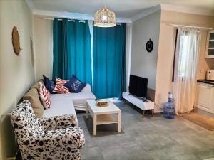 a living room with a couch and a tv at 2-Bedroom Flat with a Private Swimming Pool in Bodrum City