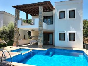 a villa with a swimming pool in front of a house at 2-Bedroom Flat with a Private Swimming Pool in Bodrum City