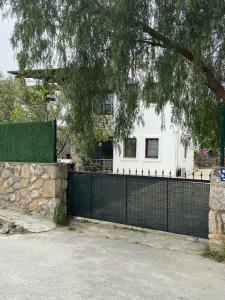 a black fence in front of a white house at 2-Bedroom Flat with a Private Swimming Pool in Bodrum City