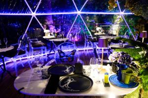 a table in a restaurant with purple lights at Forum Homini Boutique Hotel in Krugersdorp