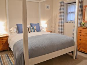 a bedroom with a large bed with blue pillows at Dairy Cottage in Marros