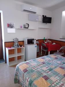 a bedroom with a bed and a kitchen and a table at CT ROOMs in Invorio Inferiore