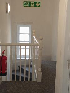 a white staircase with a window and a fire extinguisher at Bristol Hotel in Bristol