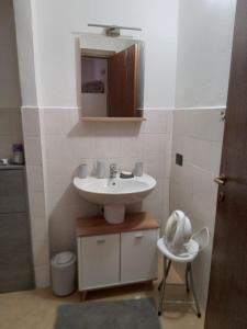 a bathroom with a sink and a mirror and a chair at CT ROOMs in Invorio Inferiore