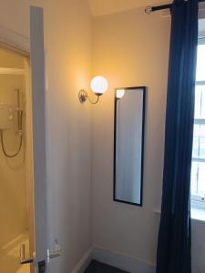 a bathroom with a mirror and a light on a wall at Bristol Hotel in Bristol