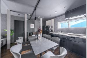 a kitchen with a dining room table and chairs at Prunoia in Furano