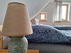 a lamp sitting on a table next to a bed at Ferienwohnung am Auenweg in Milstrich Oßling