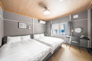 a bedroom with a bed and a desk and a window at Prunoia in Furano