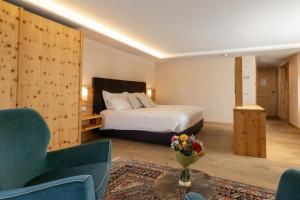 a hotel room with a bed and a couch and a table at Hotel St. Michael in Livigno +118 photos