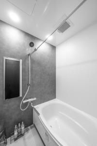 a bathroom with a bath tub with a shower at Prunoia in Furano +66 photos