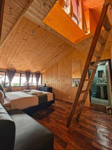 a attic bedroom with two beds and a ladder at Beyond Baari Inn in Darjeeling